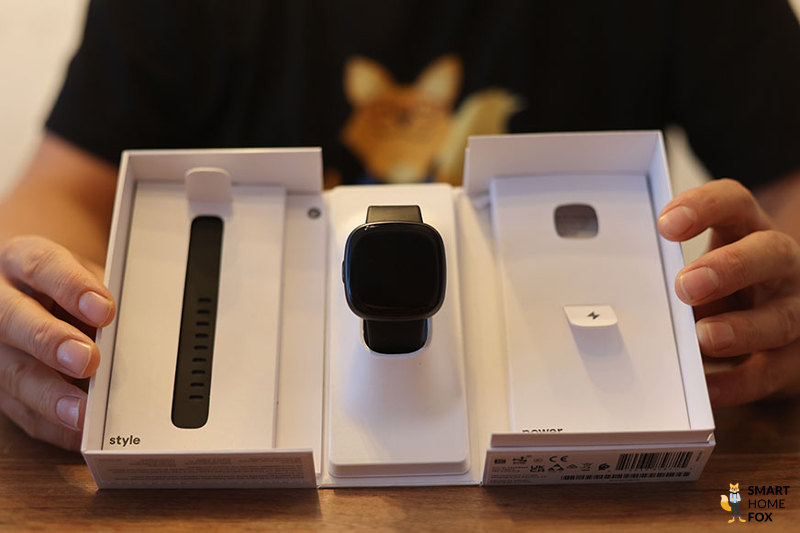 Man sieht die Fitbit Versa 4 in ihrem Karton.